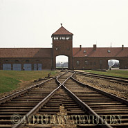 The railway siding inside Birkenau camp, with the main entrance archway, watch tower and SS guardhouse in the background